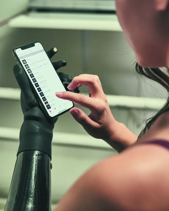 Personne utilisant un smartphone avec une main prothétique myoélectrique